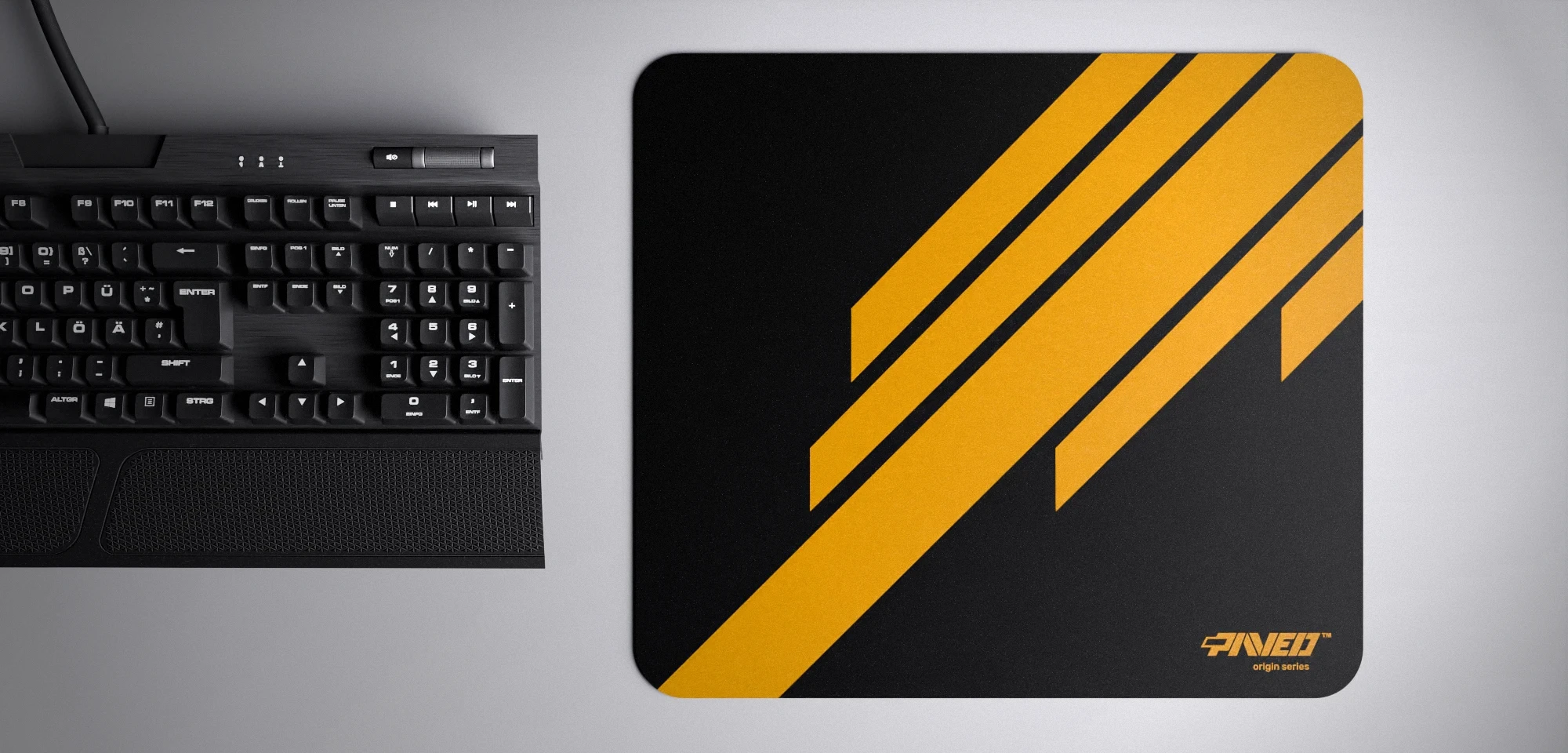 Top view of Night Desert Blade Runner M size mousepad 360mm x 320mm right-handed variant with diagonal stripe design in deep yellow and black, hydrophobic easy-to-clean surface with antimicrobial properties, shown with full-size mechanical keyboard for scale, 600% lighter with no rubbery odour base, durable stitch-free finish.