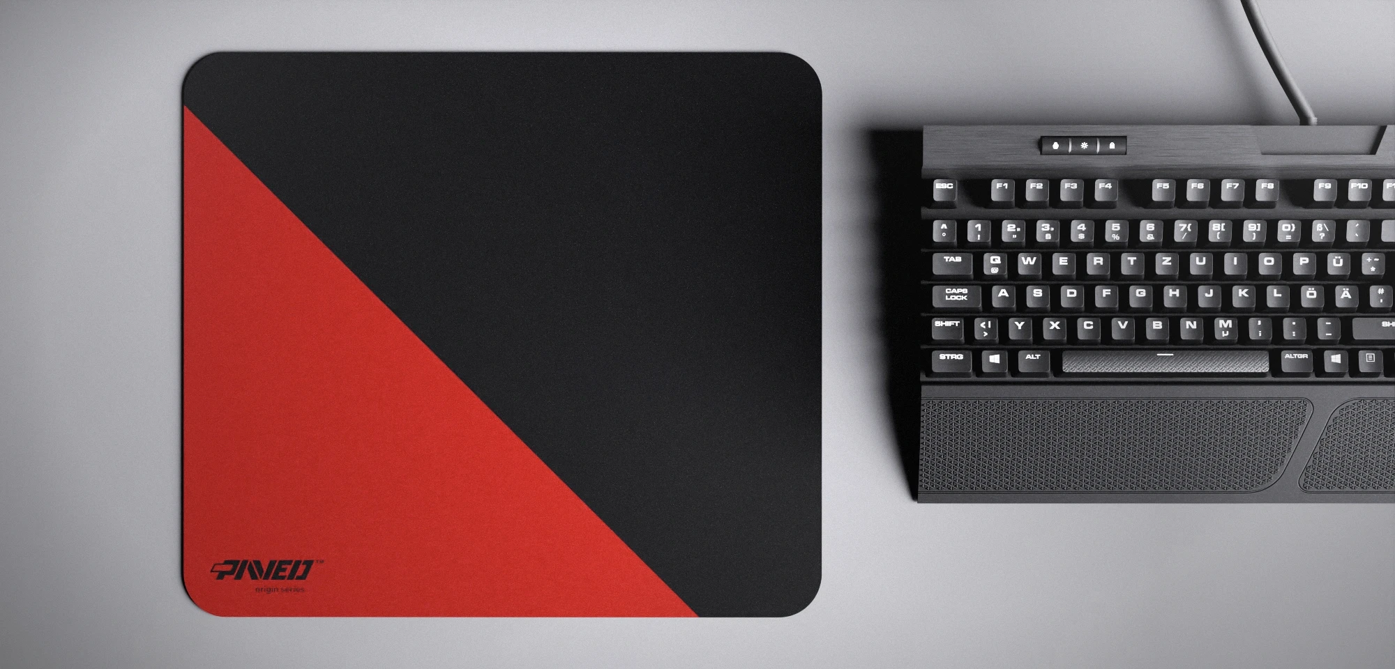 Top view of Imperial Edge Runner M size mousepad 360mm x 320mm left-handed variant with minimalistic red diagonal split design on black background, water-resistant antimicrobial polyester surface, shown with full-size mechanical keyboard for scale, ultra-lightweight odour-free AreoFlex base, stitch-free edges.