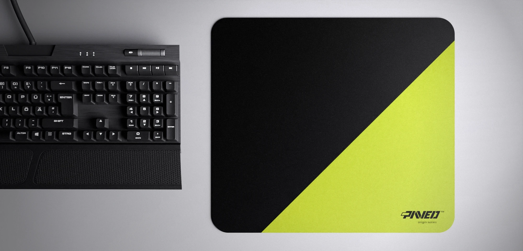 Top view of Toxic Edge Runner M size mousepad 360mm x 320mm right-handed variant with diagonal split design in light green and black, hydrophobic easy-to-clean surface with antimicrobial properties, shown with full-size mechanical keyboard for scale, 600% lighter with no rubbery odour base, durable stitch-free finish.