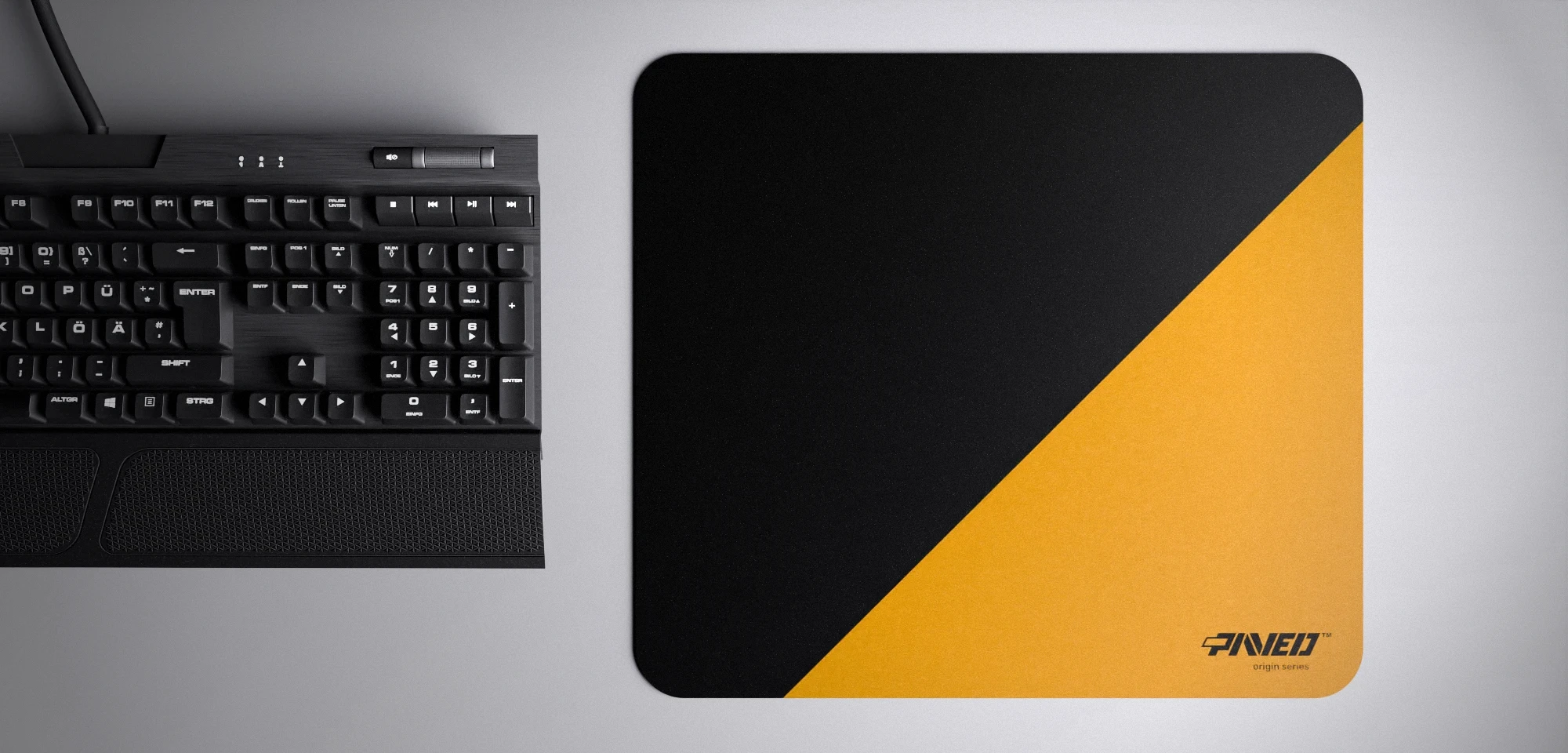 Top view of Desert Edge Runner M size mousepad 360mm x 320mm right-handed variant with diagonal split design in deep yellow and black, hydrophobic easy-to-clean surface with antimicrobial properties, shown with full-size mechanical keyboard for scale, 600% lighter with no rubbery odour base, durable stitch-free finish.