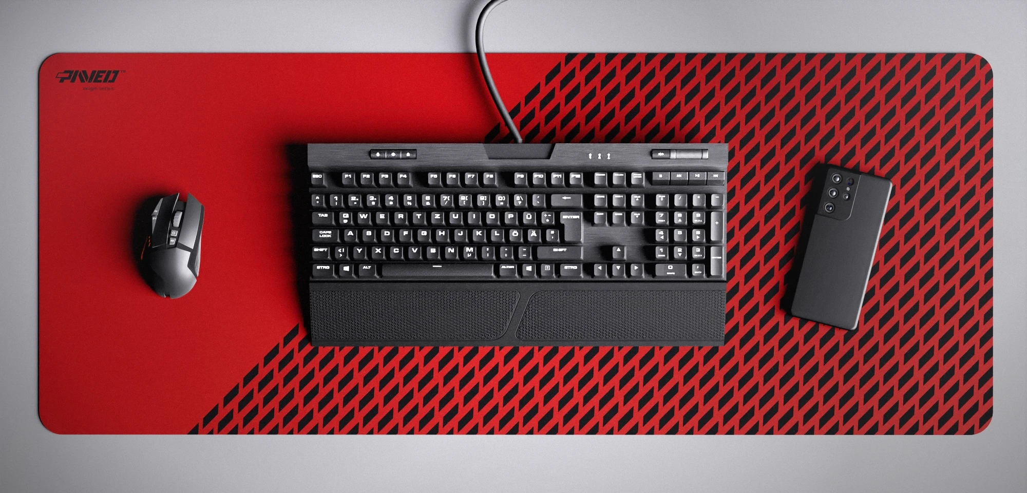 Top view of Imperial Panther XXL deskmat 1000mm x 400mm left-handed variant featuring diagonal split design with geometric panther spot pattern in red and black, water-resistant antimicrobial polyester surface, shown with full-size mechanical keyboard, gaming mouse, and smartphone for scale, ultra-lightweight odour-free AreoFlex microruber base, stitch-free professional finish.