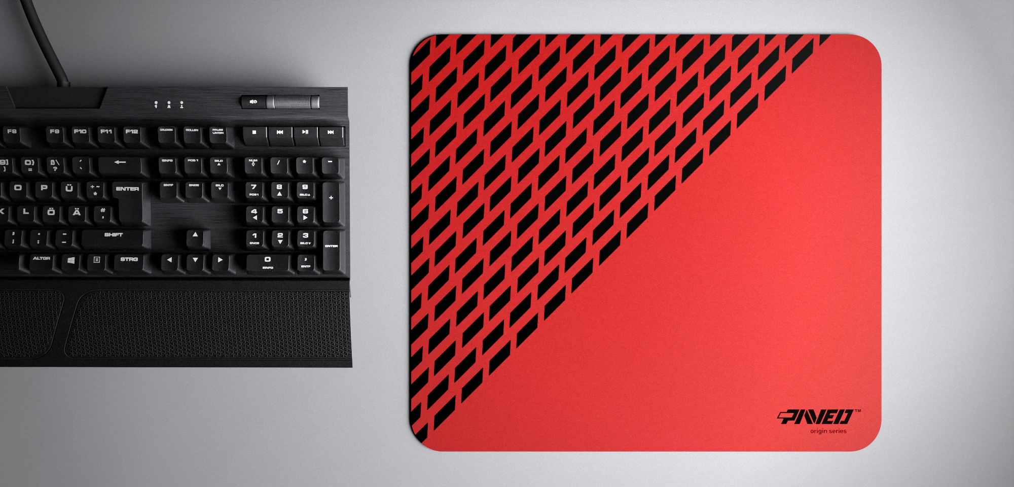 Top view of Imperial Panther M size mousepad 360mm x 320mm right-handed variant with diagonal split design and geometric panther spot pattern in red and black, hydrophobic easy-to-clean surface with antimicrobial properties, shown with full-size mechanical keyboard for scale, 600% lighter with no rubbery odour base, durable stitch-free finish.