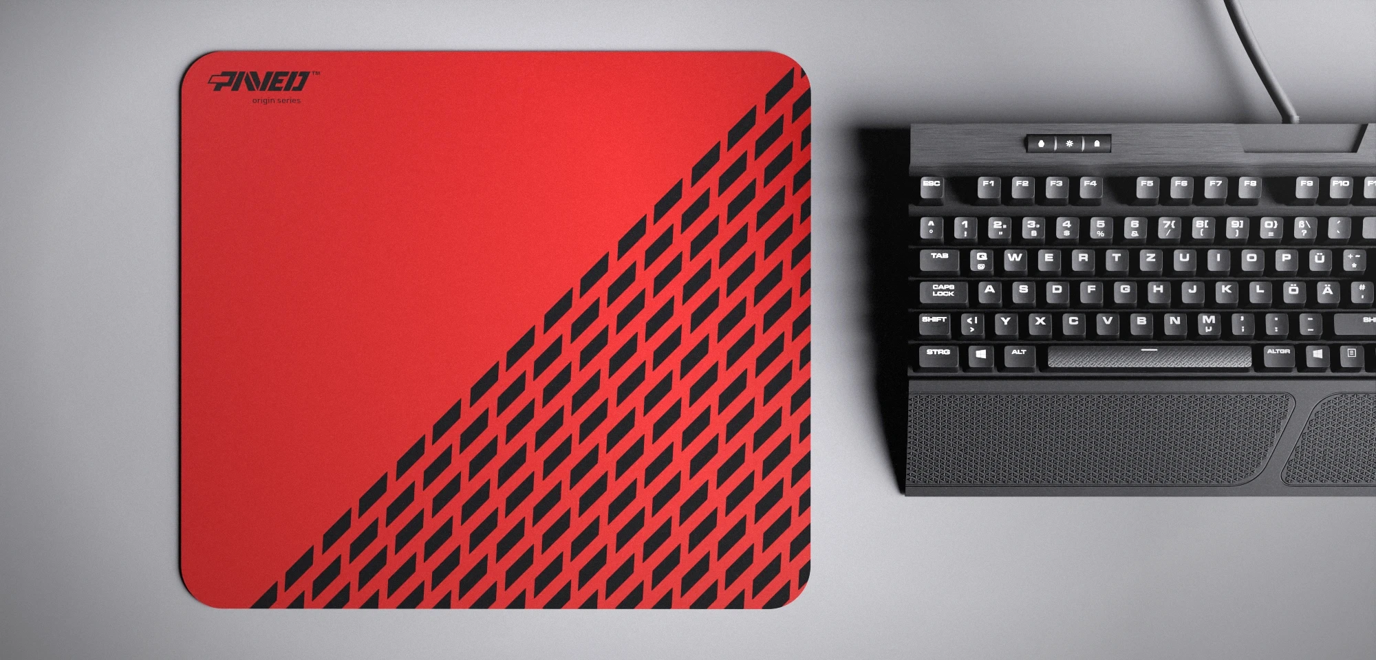 Top view of Imperial Panther M size mousepad 360mm x 320mm left-handed variant with minimalistic red geometric panther spot pattern on black background with diagonal split design, water-resistant antimicrobial polyester surface, shown with full-size mechanical keyboard for scale, ultra-lightweight odour-free AreoFlex base, stitch-free edges.