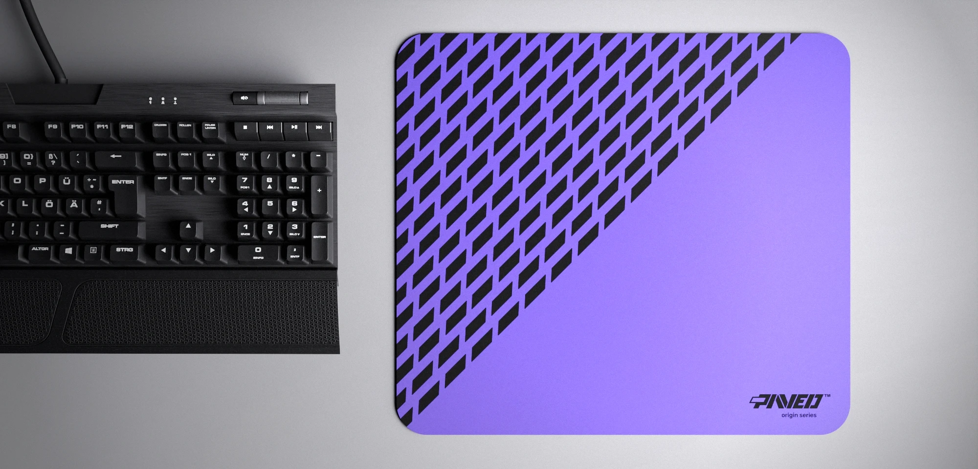 Top view of Amethyst Panther M size mousepad 360mm x 320mm right-handed variant with diagonal split design and geometric panther spot pattern in purple and black, hydrophobic easy-to-clean surface with antimicrobial properties, shown with full-size mechanical keyboard for scale, 600% lighter with no rubbery odour base, durable stitch-free finish.
