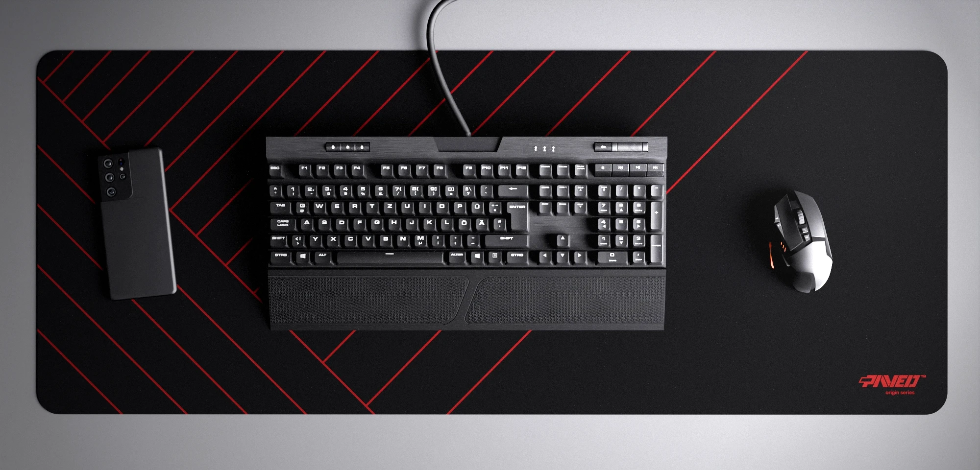 Top view of Night Imperial Zebra XXL deskmat 1000mm x 400mm right-handed variant with minimalistic diagonal stripe pattern in red and black, hydrophobic easy-to-clean antimicrobial surface, shown with full-size mechanical keyboard, gaming mouse, and smartphone for scale, 600% lighter non-slip base with no rubbery smell, durable stitch-free edges.