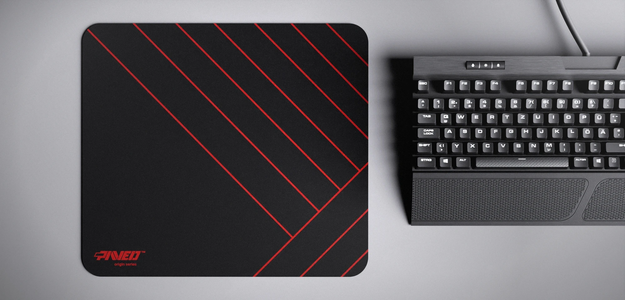 Top view of Night Imperial Zebra M size mousepad 360mm x 320mm left-handed variant with minimalistic red diagonal stripe pattern on black background, water-resistant antimicrobial polyester surface, shown with full-size mechanical keyboard for scale, ultra-lightweight odour-free AreoFlex base, stitch-free edges.