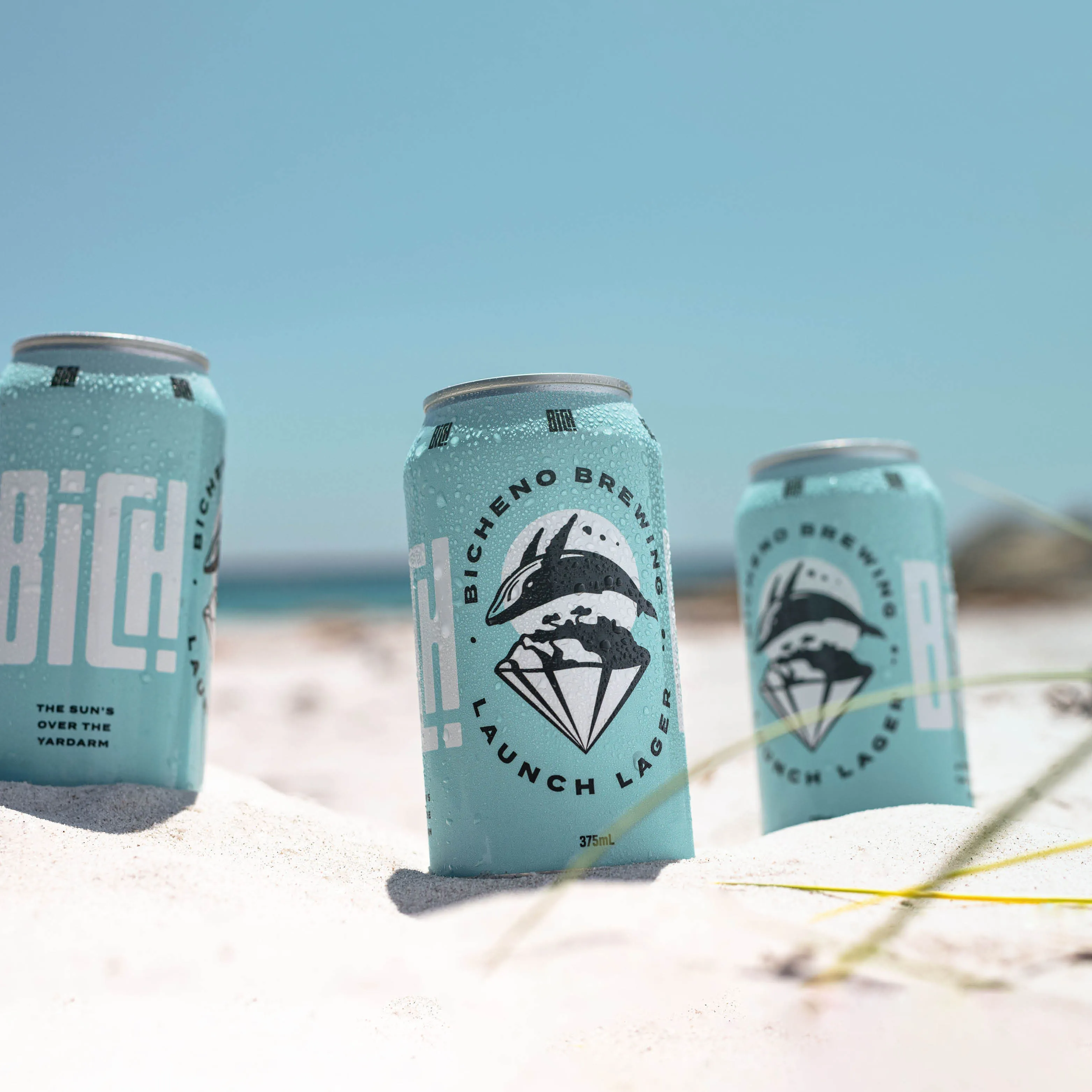 A can of Bicheno Brewing Launch Lager sitting on the beach