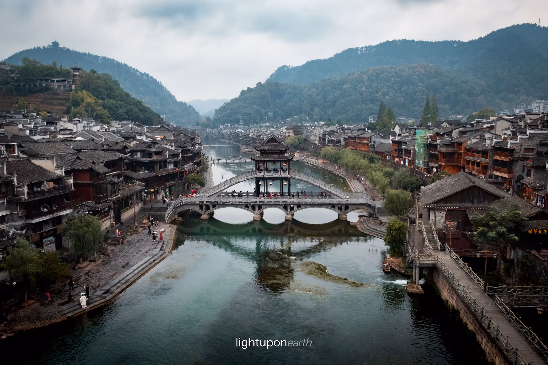 Bridge leading over river with traditional houses on both sides