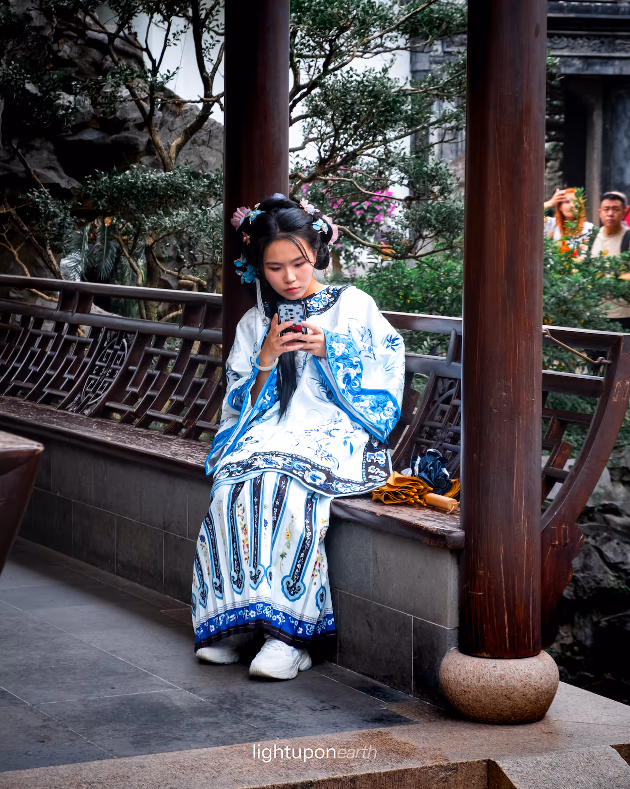 girl wearing traditional chinese clothes sitting in Yu garden
