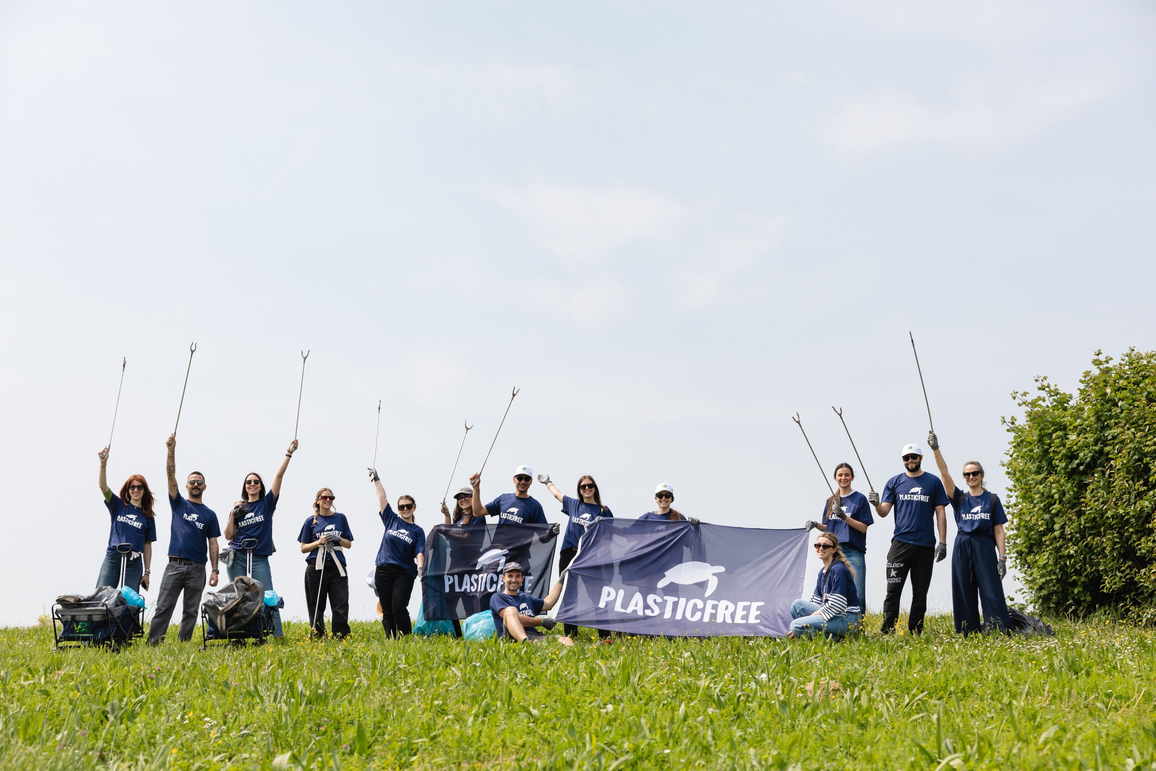 Foto di gruppo del team di 2night con lo striscione Plastic Free al Parco San Giuliano