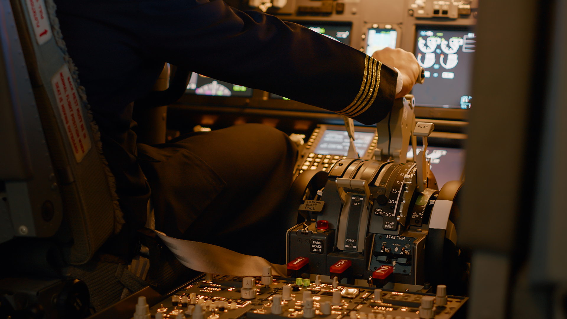 A pilot in uniform operating throttle controls inside a commercial aircraft cockpit, ensuring performance monitoring.