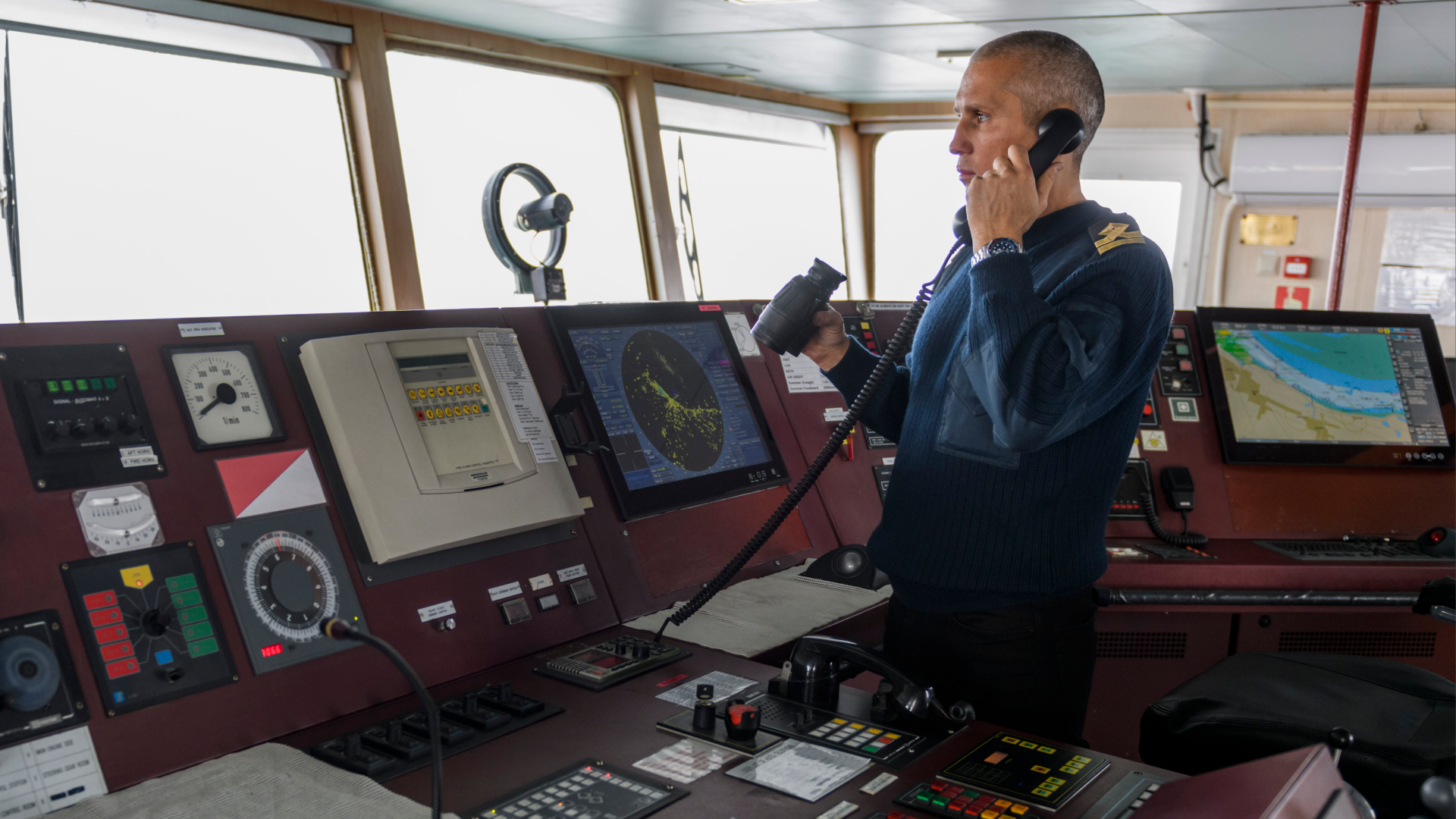 Officer communicating on bridge controls, illustrating communication risks related to Dirty Dozen human factors.
