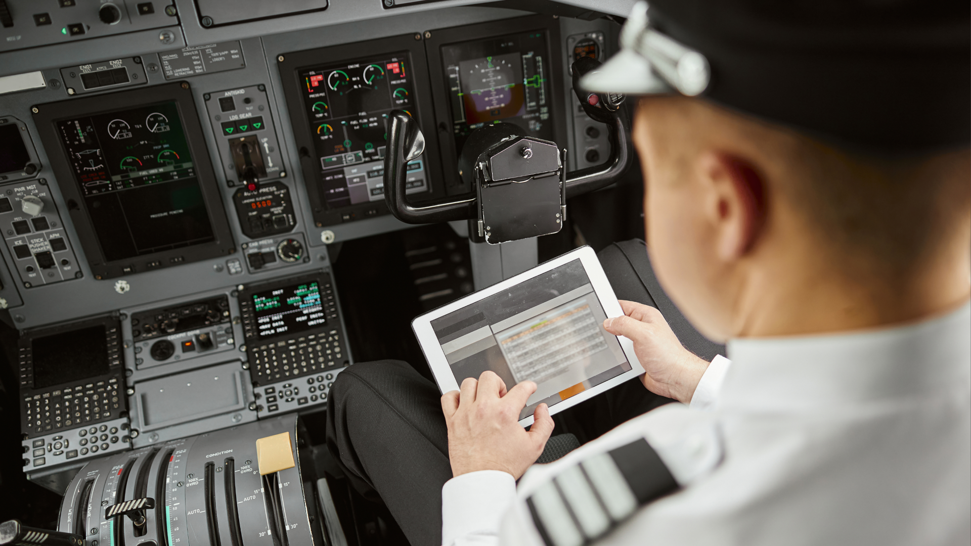 Pilot reviewing operational data on tablet inside cockpit during aviation safety review.
