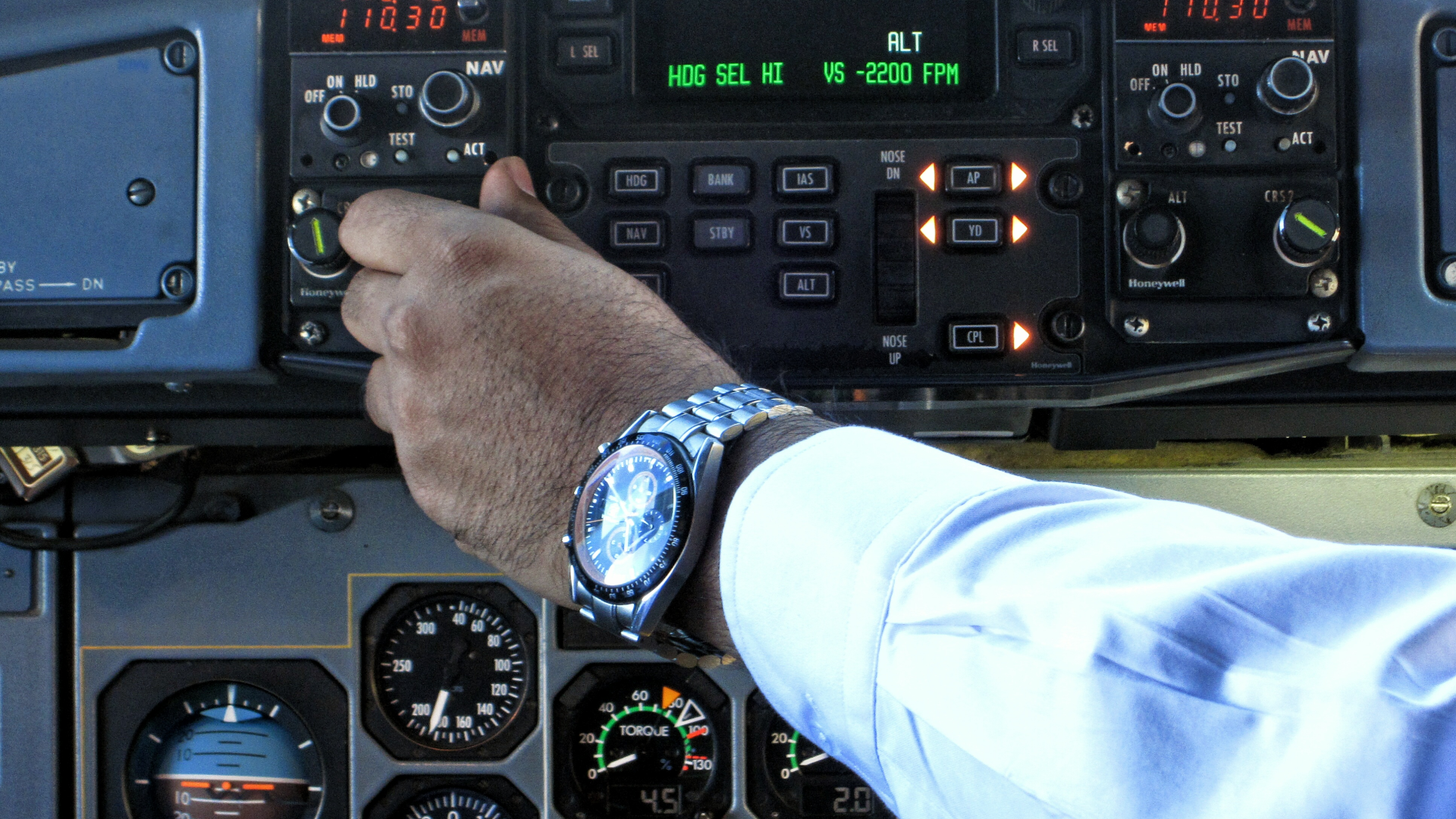 Pilot adjusting cockpit controls while preparing aircraft systems during pre-flight inspection.