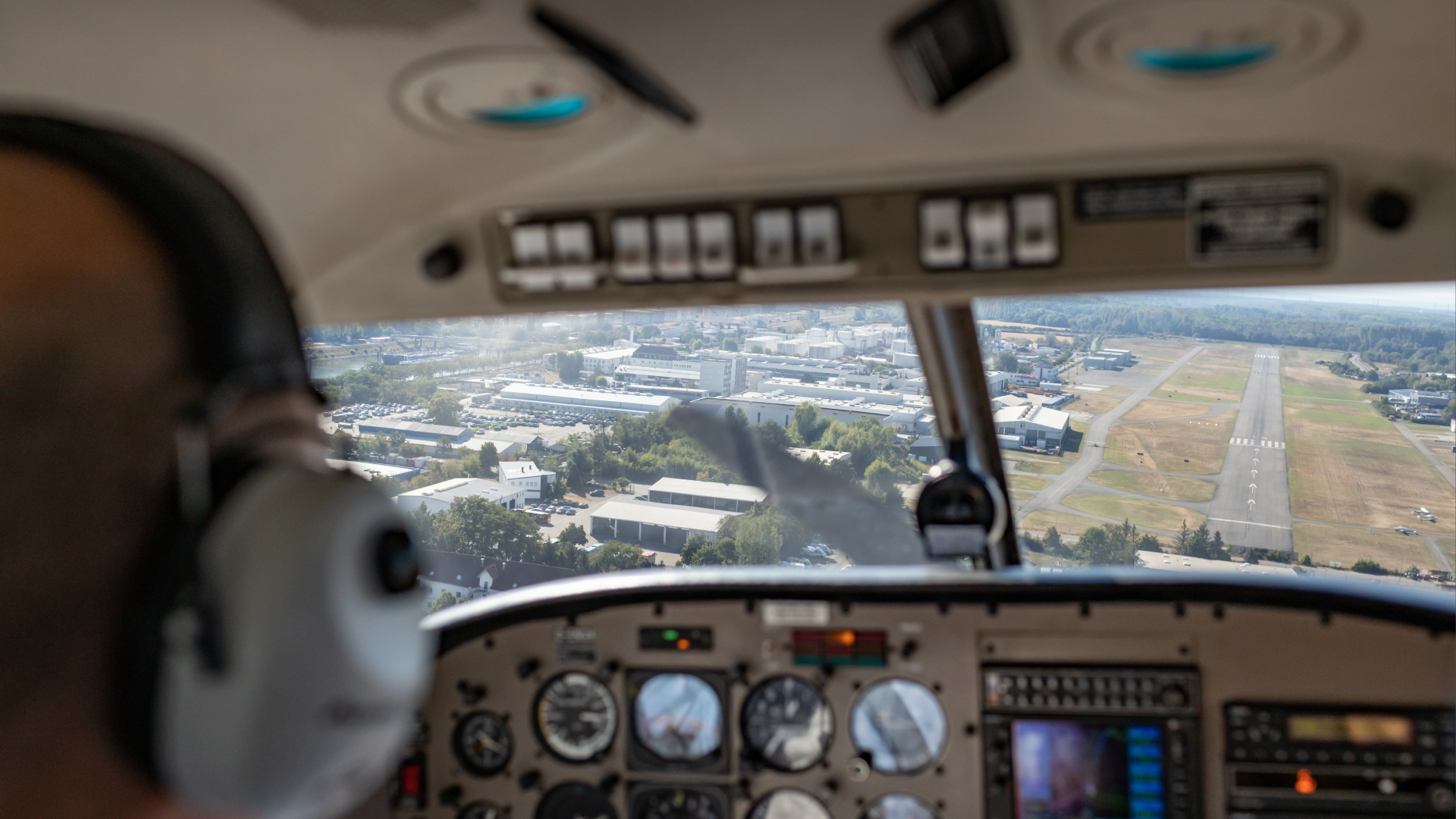 Cockpit view of aircraft approaching runway during landing at a regional airport.