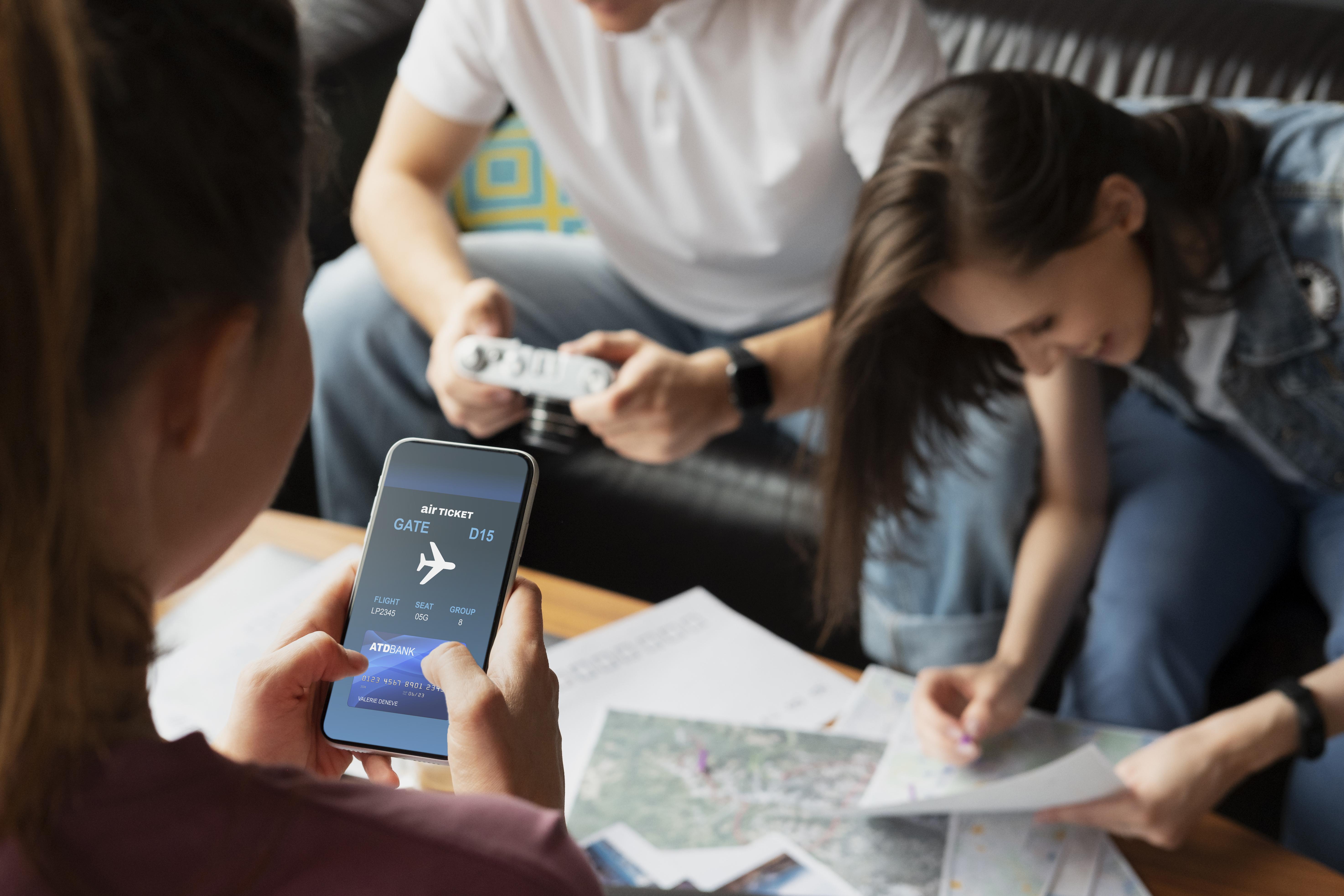 A group of people review a flight route on paper maps and an app.
