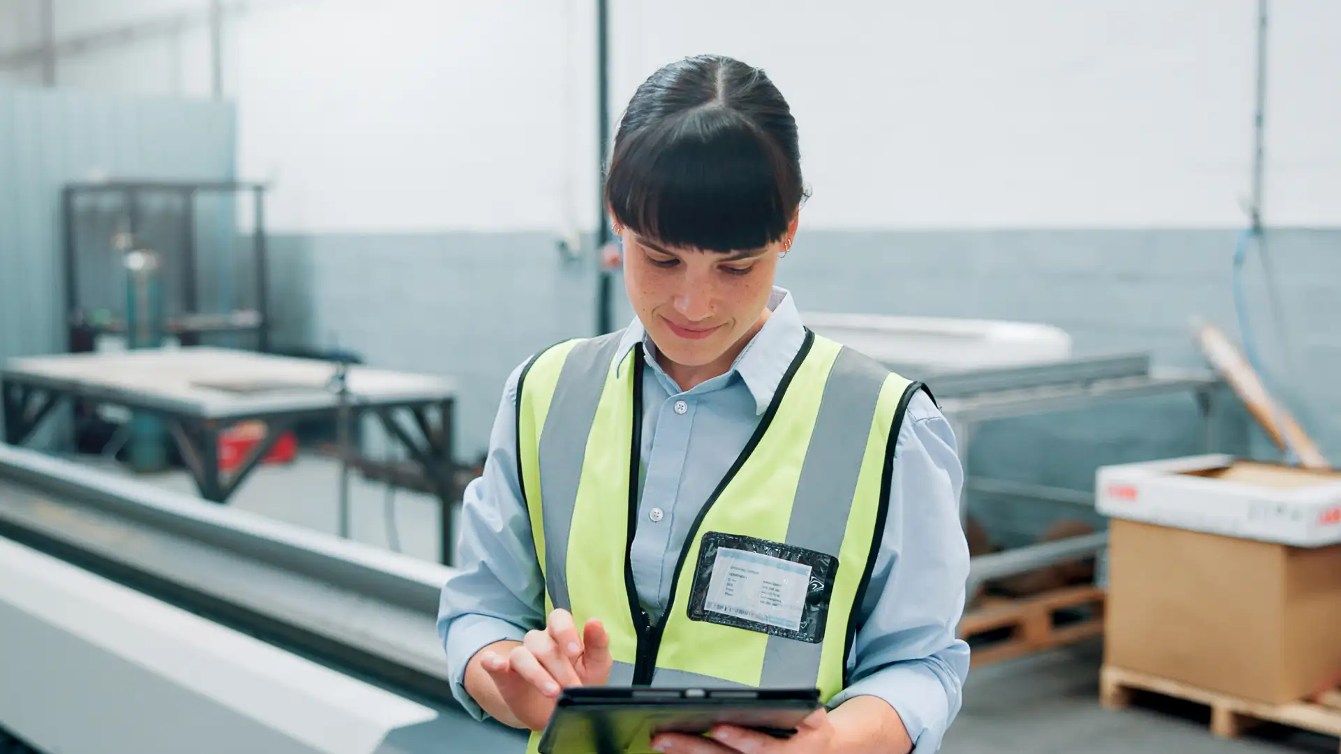 Maintenance professional using a tablet to review inspection planning information, representing coordination of flight hours and maintenance scheduling.