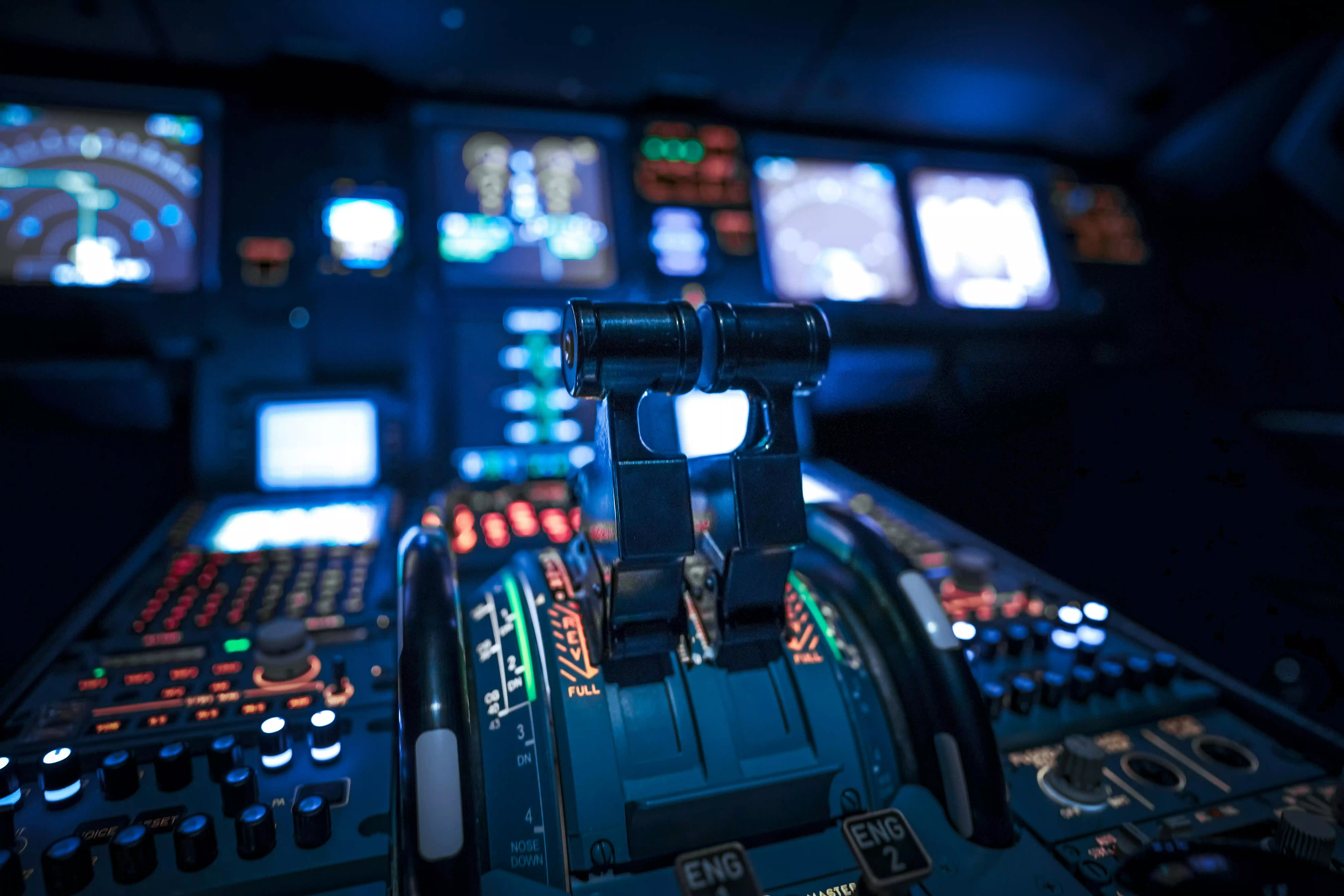 Close-up view of illuminated aircraft throttle controls and autopilot systems in a dim cockpit, highlighting switches, levers, and navigation screens essential for flight director integration and efficiency.