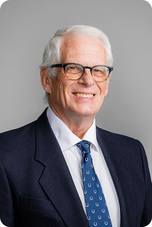 headshot of president dr donald jones, wearing a suit with blue tie, smiling, glasses 