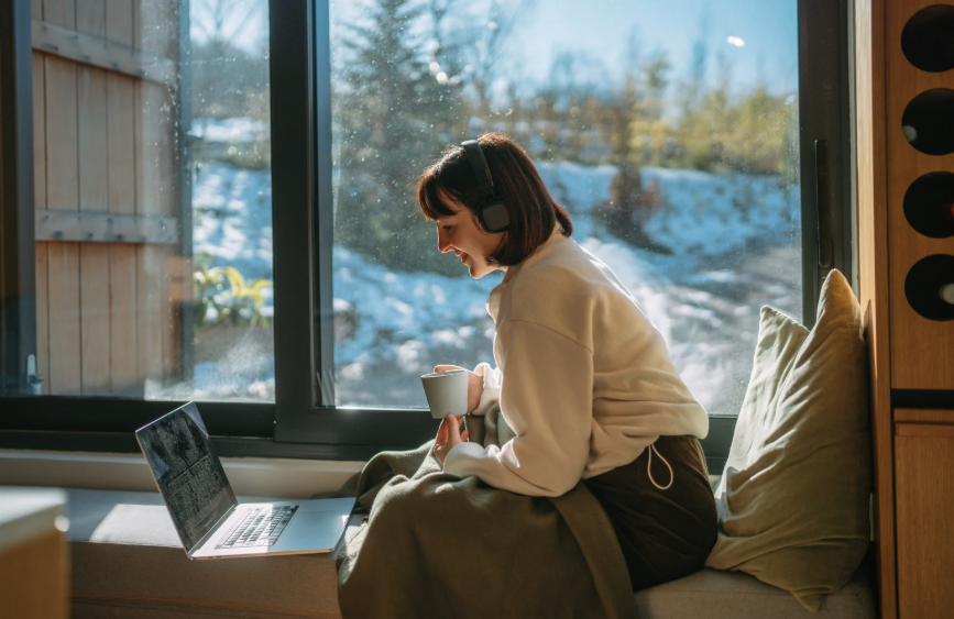 Two women sitting and looking at an ipad screen and smiling as one is pointing to the ipad 