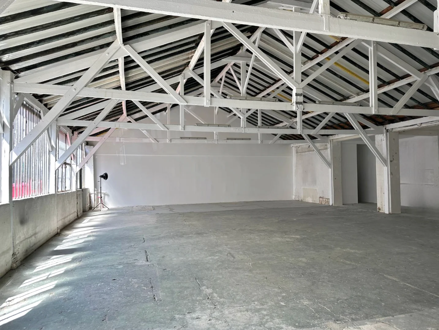 Atelier sur Cour chez Artefact Paris, montrant un espace flexible avec des chaises en bois rustiques et une échelle, prêt à être transformé pour des vernissages ou des espaces créatifs.