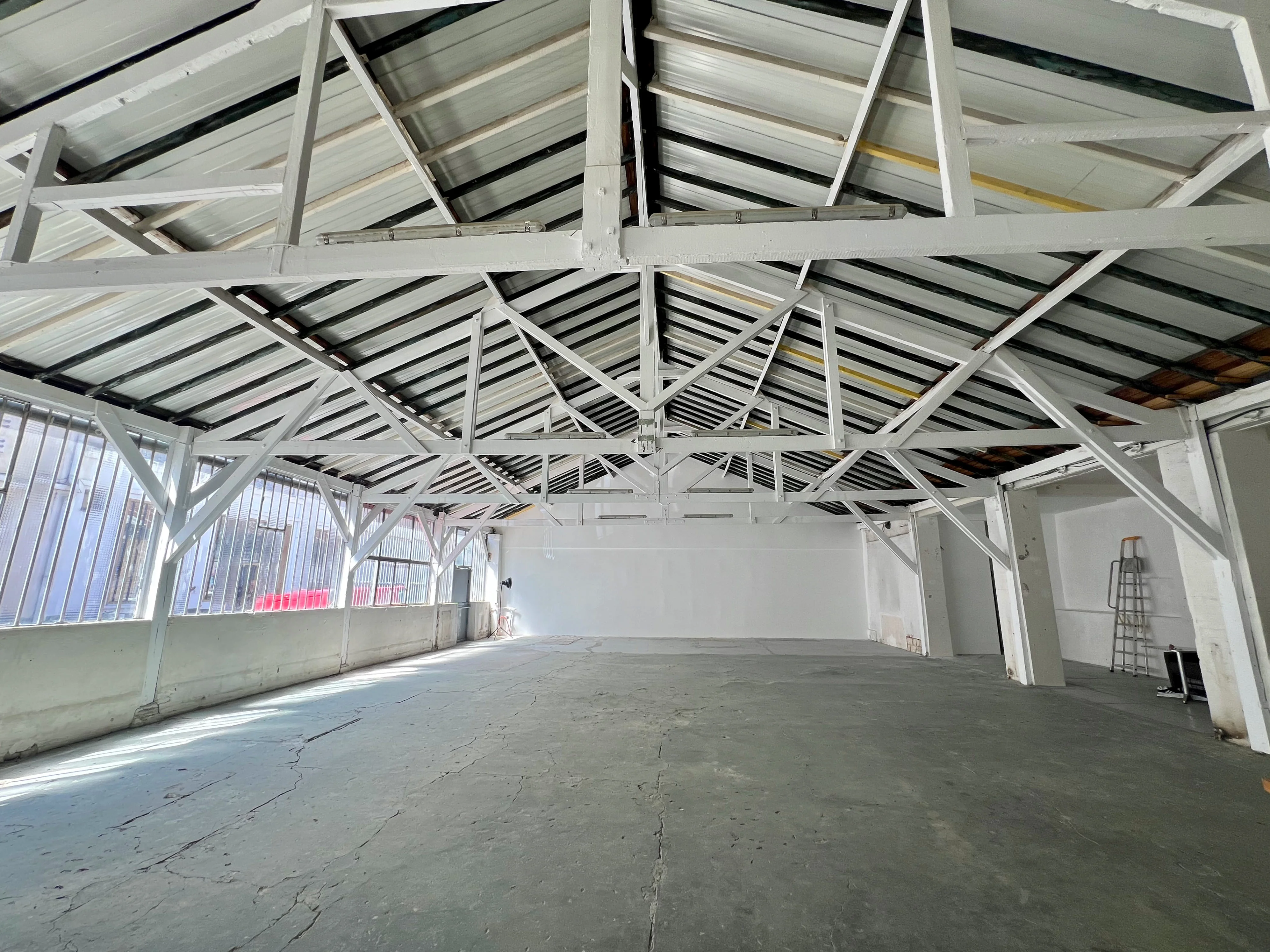 Espace lumineux de l'Atelier sur Cour chez Artefact Paris, avec des fenêtres donnant sur une cour arborée, mettant en valeur la tranquillité et l'intimité du lieu pour des événements artistiques et des ateliers.