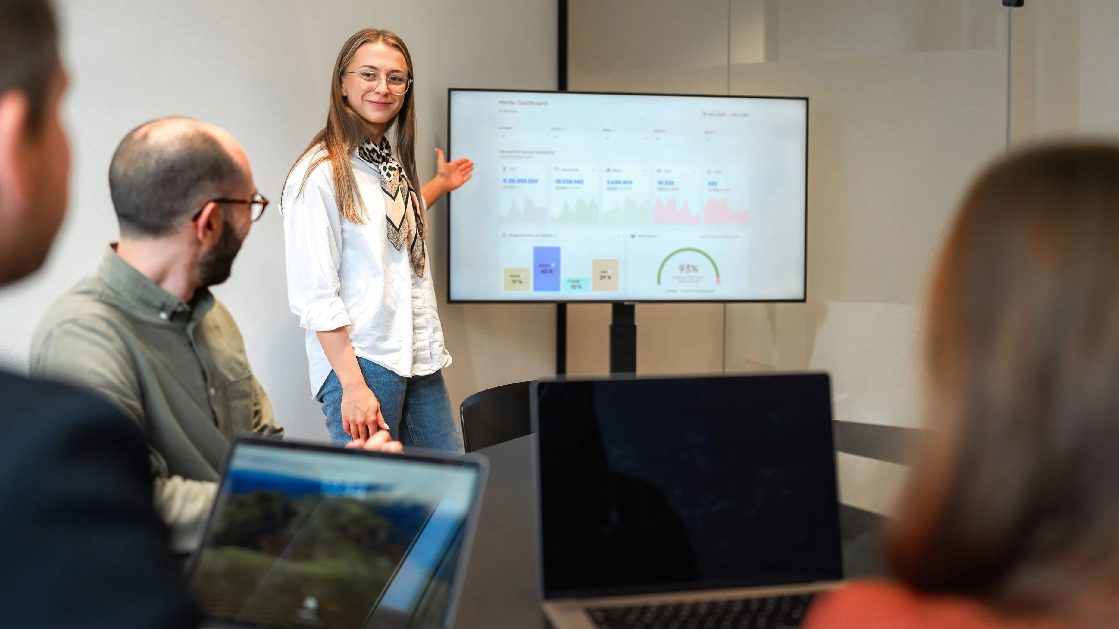 A large screen in a company meeting room displaying a data dashboard with charts and graph, that are the result of automated marketing data accuracy thanks to Accutics Validate.