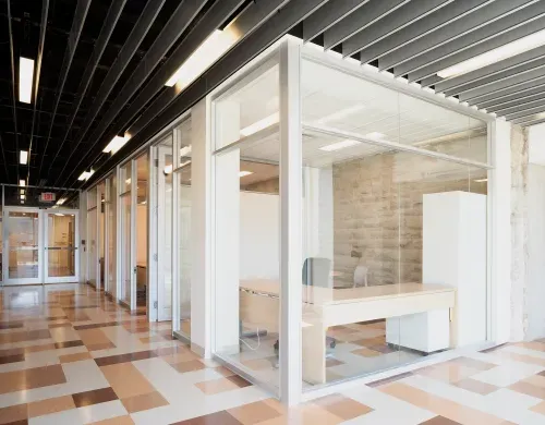 Western University’s Material Science office corridor, with glass walls leading to office spaces with exposed brick walls