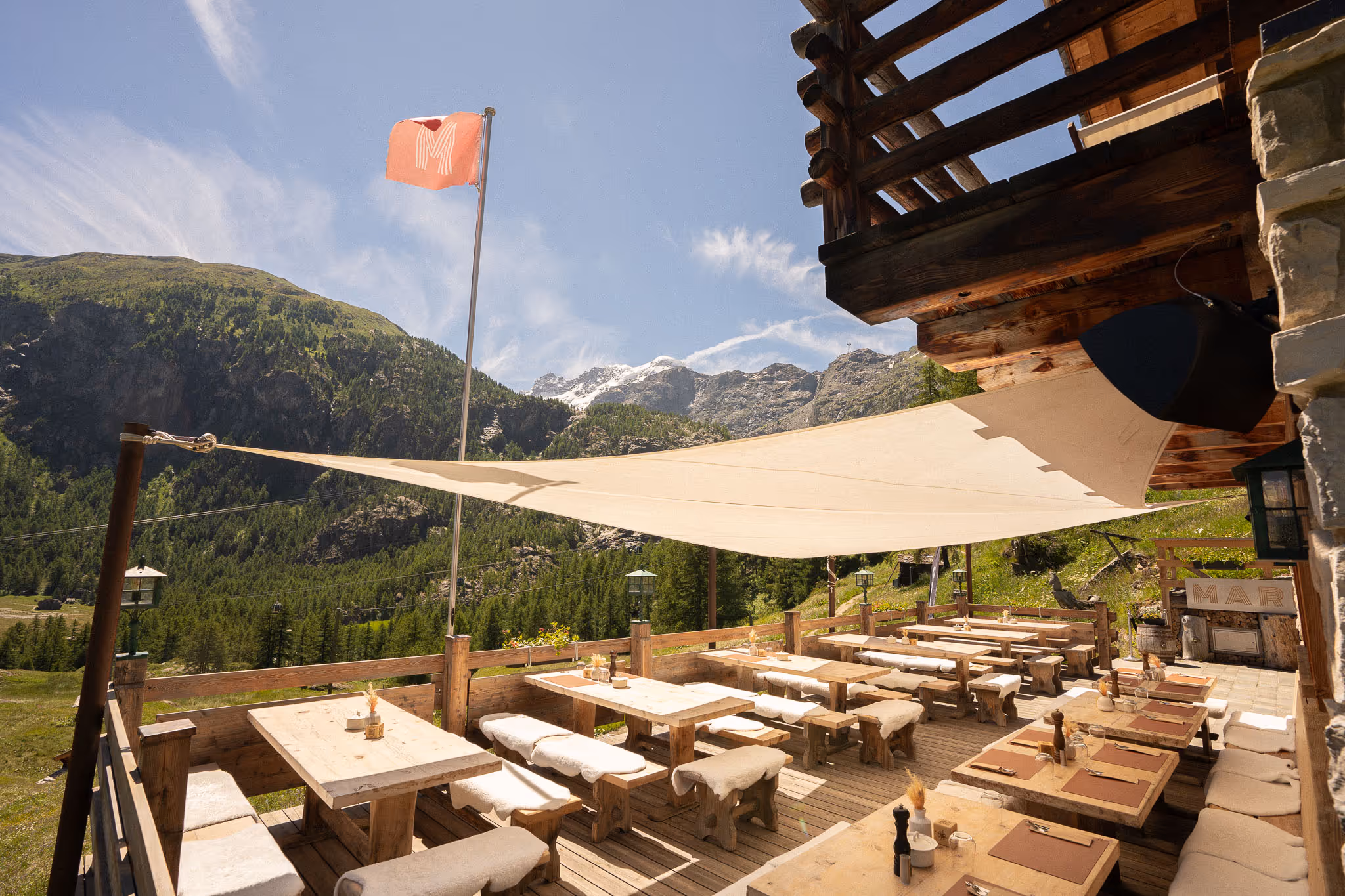 Sunny outdoor terrace at Restaurant Marmo Furi with alpine mountain views in Zermatt