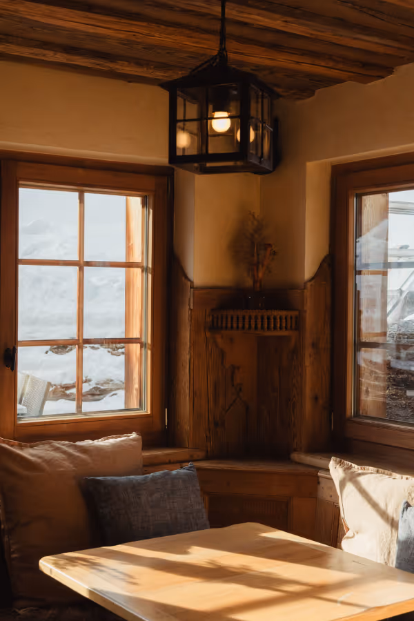 Cosy interior nook with wooden panelling and snowy mountain views at Chalet Furi Zermatt