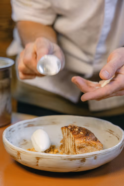 Chef plating a layered dessert with cream at Restaurant Marmo Furi Zermatt