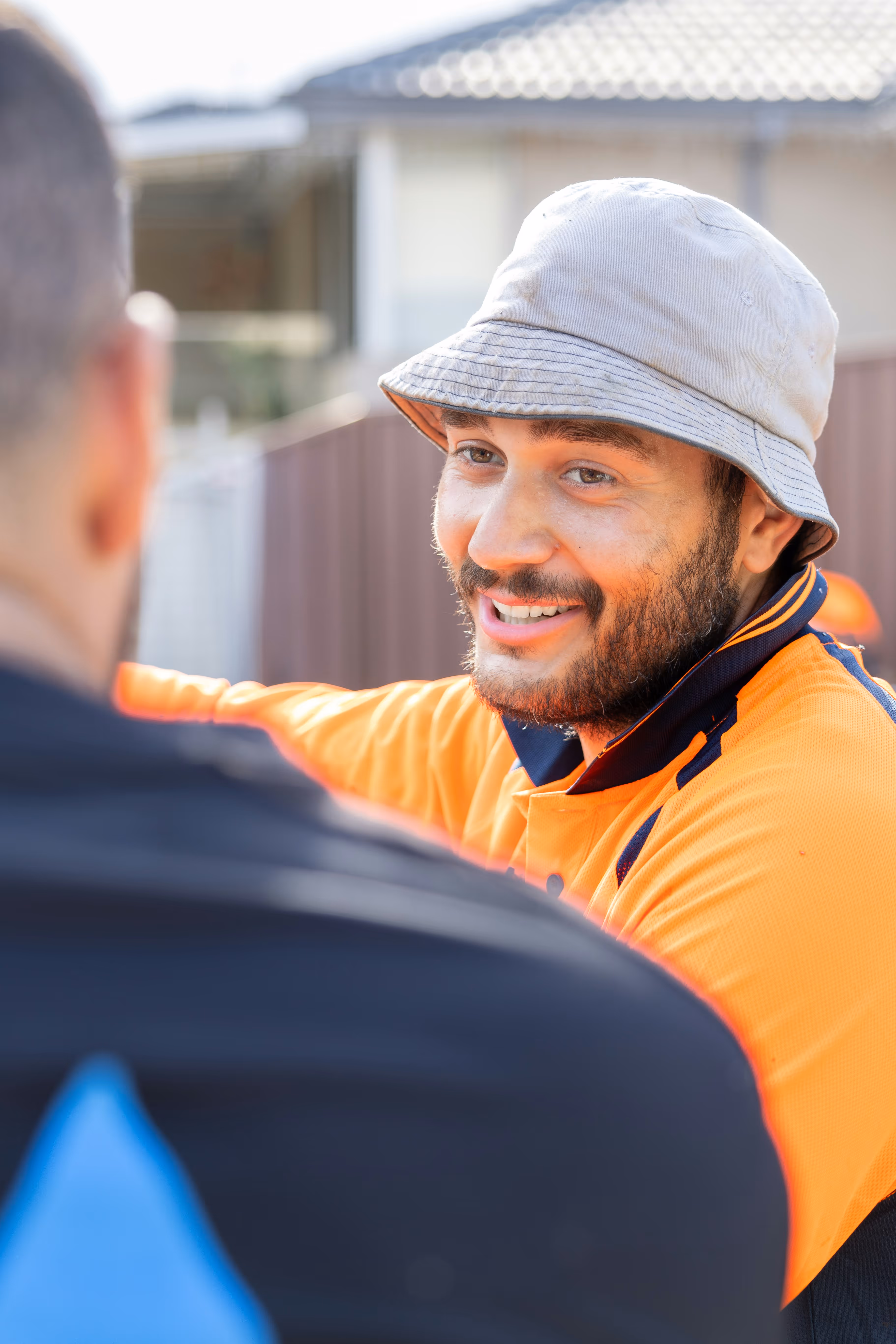 Australian worker in hi-vis uniform smiling during conversation with a colleague