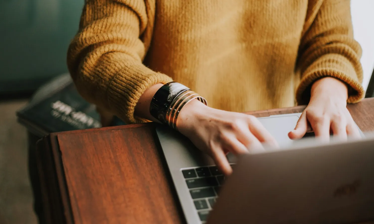 A person is typing on their Macbook.