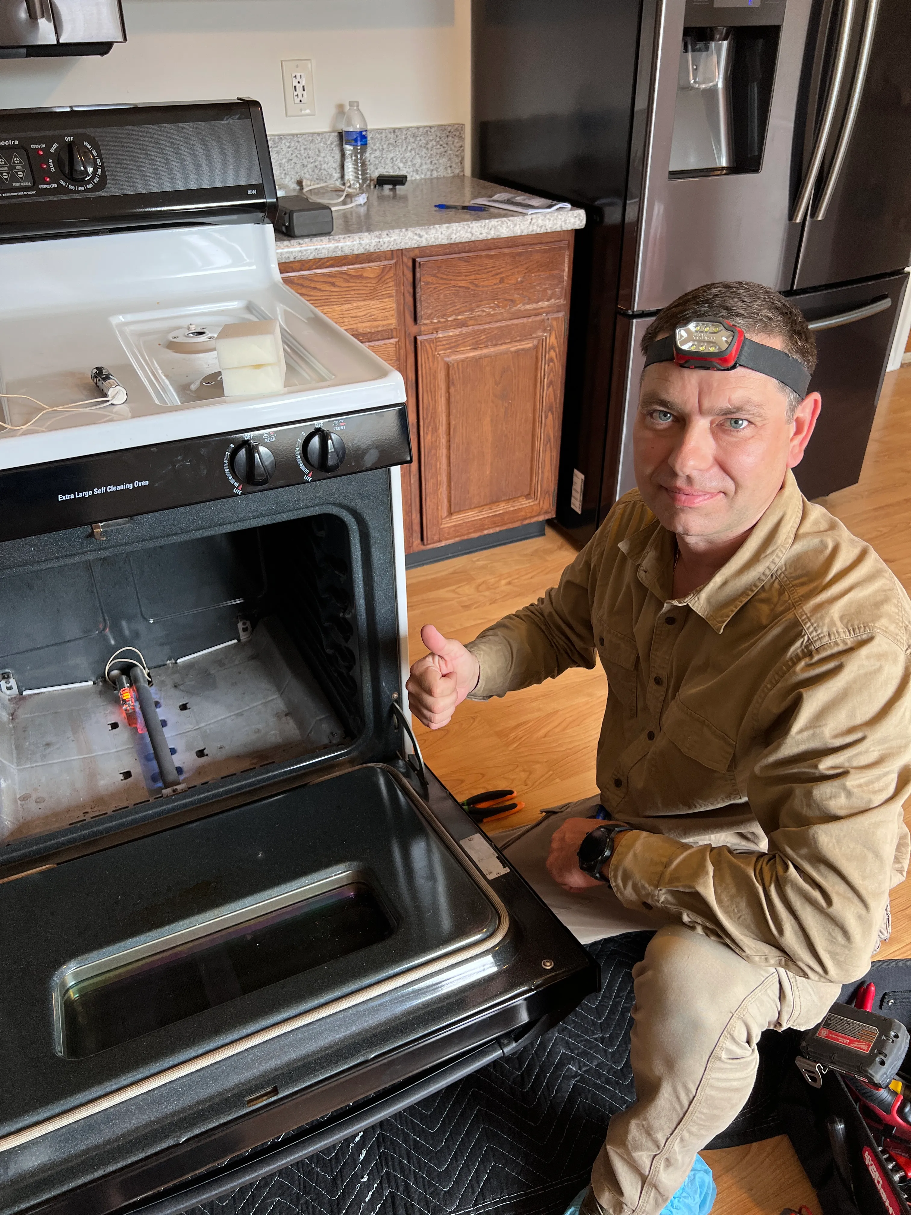 Ivan, owner of IVAN Appliance Repairs, repairing a gas oven in a Chicago-area home