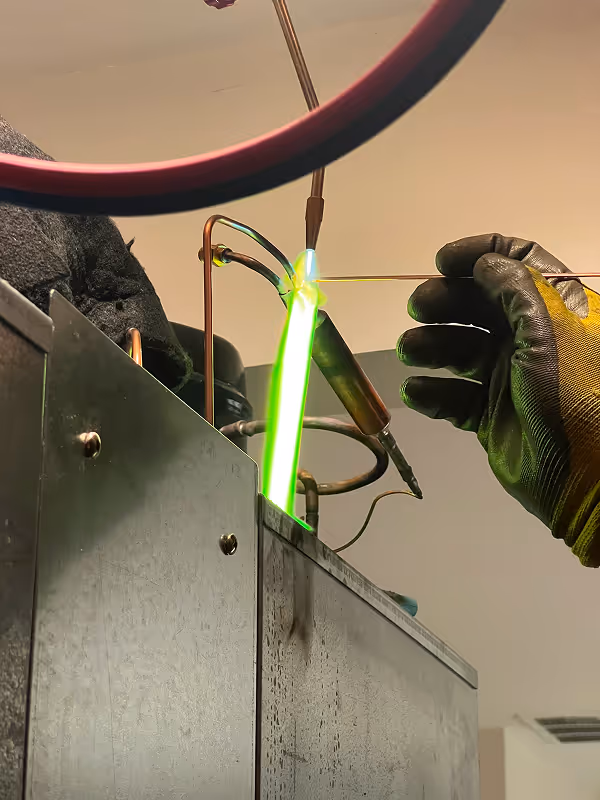 Close-up of brazing torch repairing copper refrigerant line