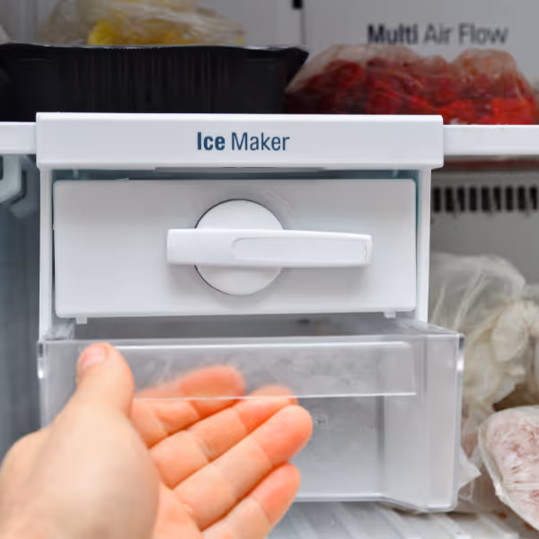 Technician checking ice maker inside freezer