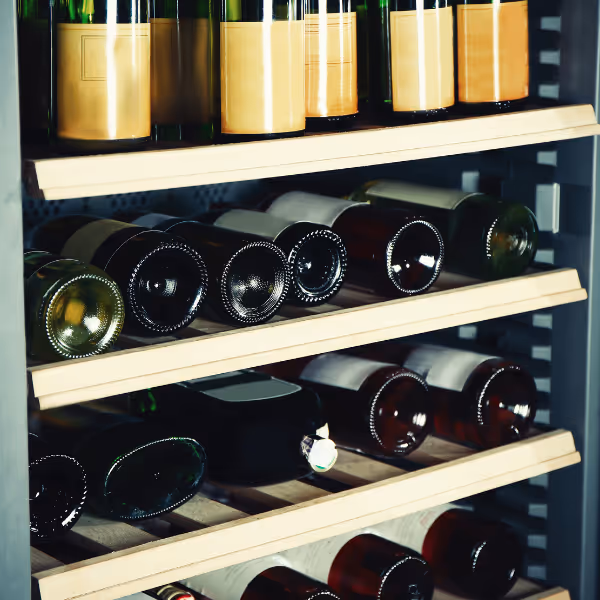 Wine bottles stored on wooden wine cooler shelves