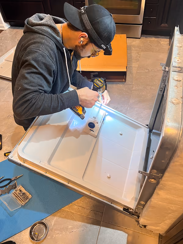 Appliance repair technician repairing a washer