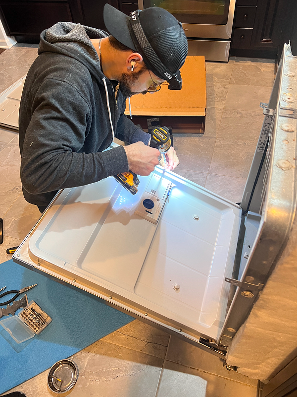 Appliance repair technician repairing a washer