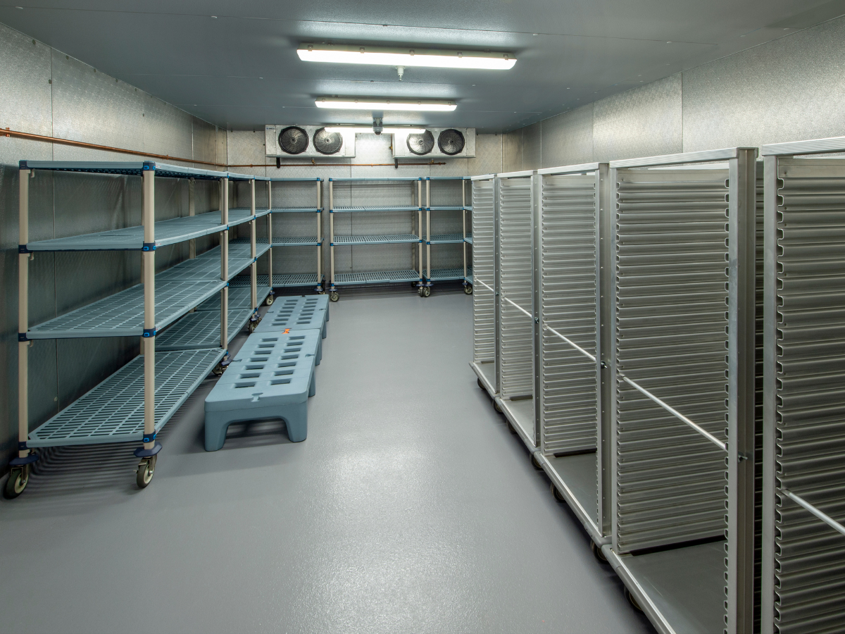 Large walk-in cooler with storage racks and cooling fans