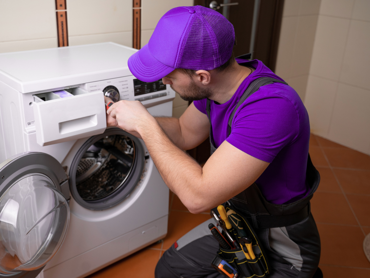Appliance repair technician repairing a washer