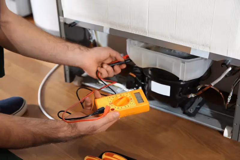 Appliance technician testing refrigerator components with digital multimeter 4️⃣