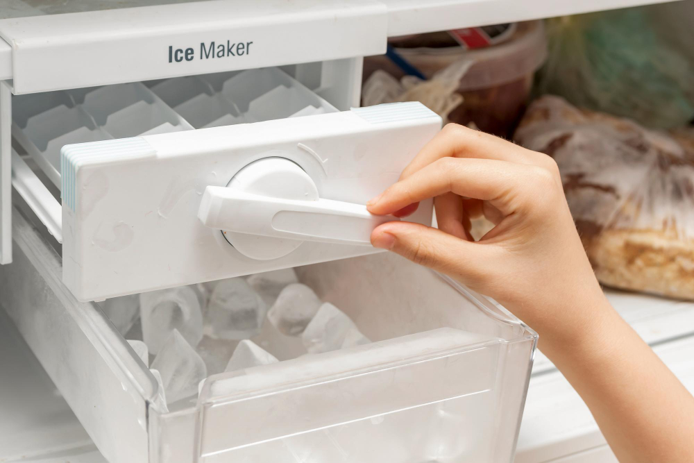 Hand opening refrigerator ice maker compartment to check ice production