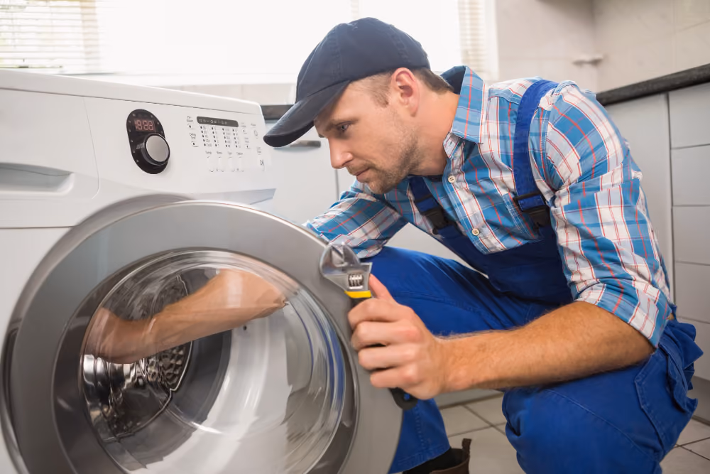 Appliance technician fixing a washing machine