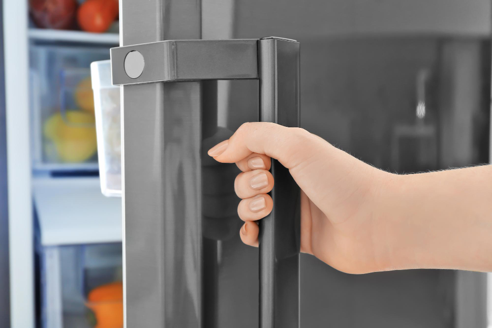 Woman closing refrigerator door closeup