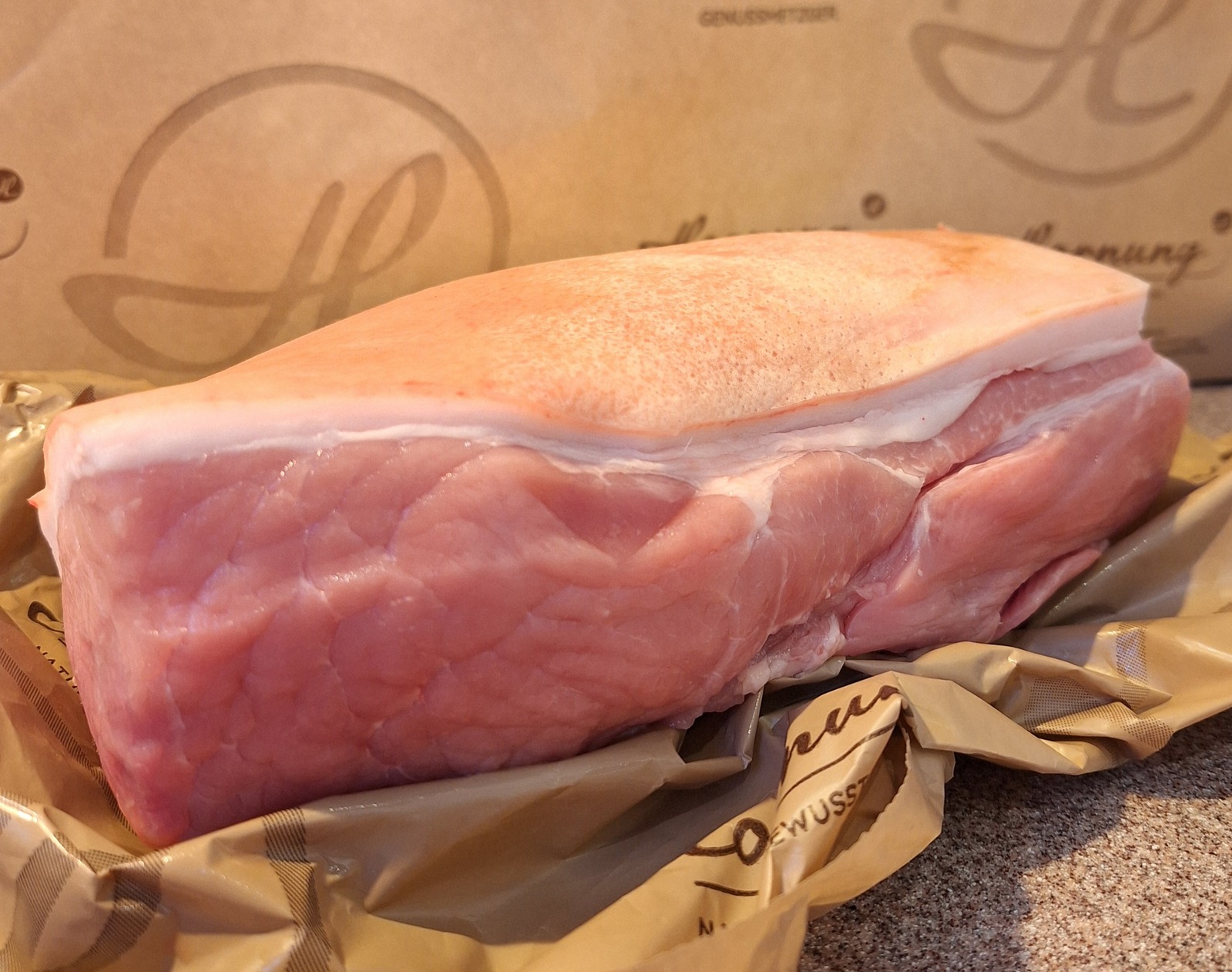 Ein frisches Stück Schweine-Hüfte liegt auf einer Papiertüte mit Hornung-Logo