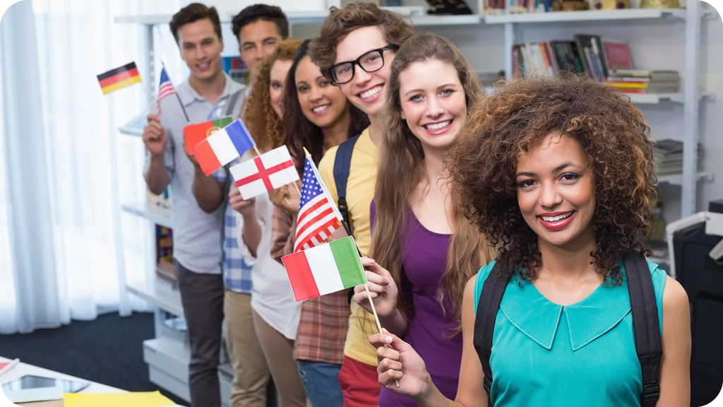 Jeune homme souriant en visioconférence, parlant plusieurs langues avec des drapeaux internationaux en arrière-plan - BSB