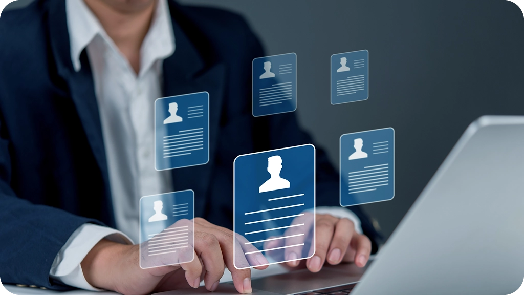 Professionnel en costume utilisant un ordinateur portable avec des icônes de profils numériques flottants, représentant la gestion des talents et des ressources humaines par un DRH moderne – BSB