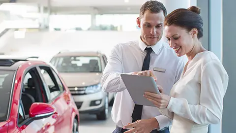 Woman and man at a dealership checking a tablet
