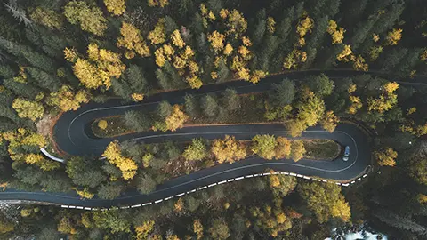 Car driving winding autumn road